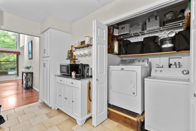 laundry area with washing machine and clothes dryer and baseboards