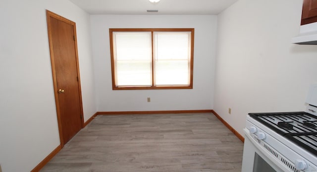 kitchen with white range with gas cooktop, light wood finished floors, baseboards, and under cabinet range hood