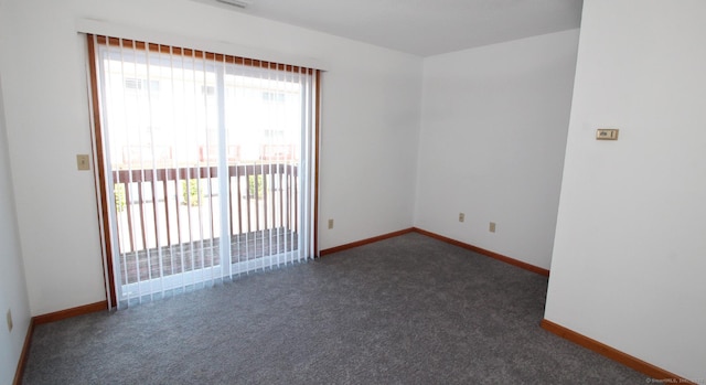 carpeted spare room featuring baseboards