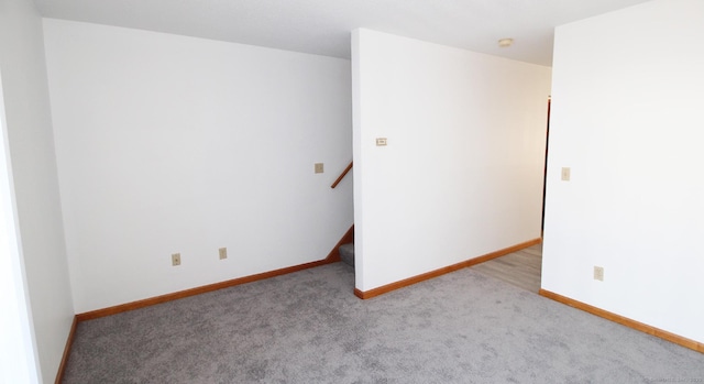 spare room with carpet floors, baseboards, and a smoke detector