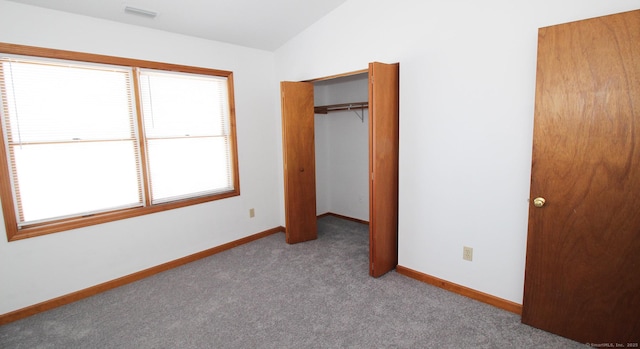 unfurnished bedroom with carpet, lofted ceiling, baseboards, and a closet