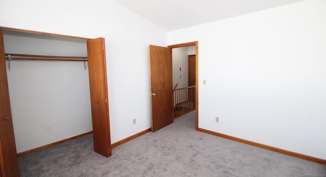 unfurnished bedroom with carpet flooring, a closet, and baseboards