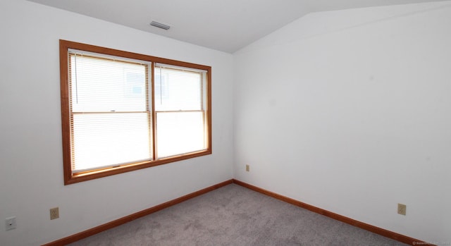 unfurnished room with vaulted ceiling, baseboards, and light colored carpet