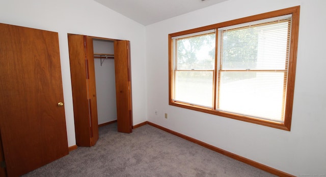 unfurnished bedroom featuring vaulted ceiling, carpet, and baseboards
