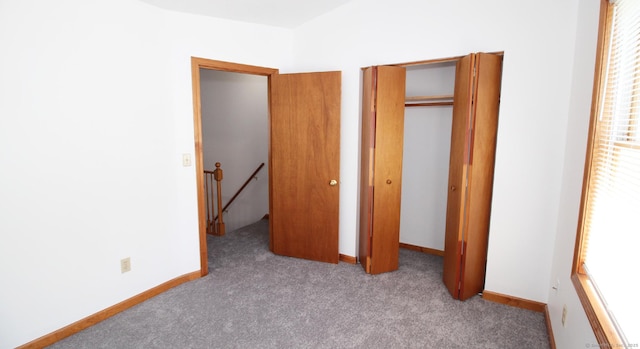 unfurnished bedroom featuring carpet, a closet, and baseboards