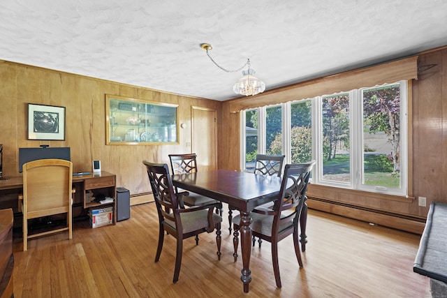 241 Clarks Falls Rd, North Stonington, CT 06359 - dining room featuring a baseboard heating unit, a chandelier, wooden walls, wood finished floors, and a textured ceiling