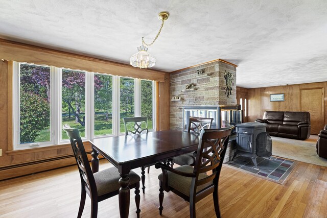 241 Clarks Falls Rd, North Stonington, CT 06359 - dining room with light wood finished floors, a chandelier, wooden walls, a stone fireplace, and a textured ceiling