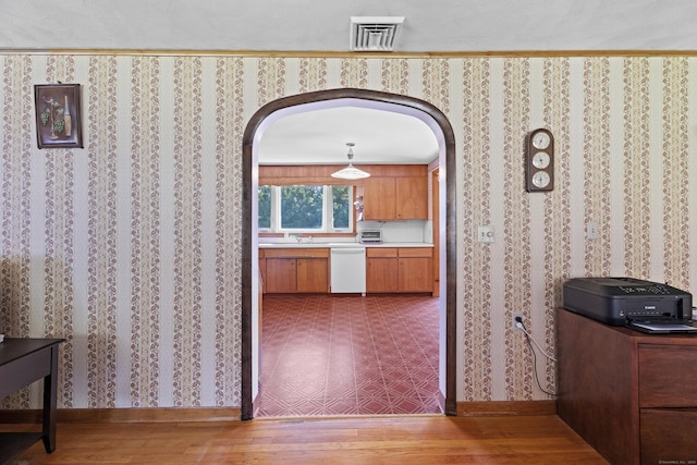 241 Clarks Falls Rd, North Stonington, CT 06359 - kitchen featuring arched walkways, white dishwasher, wood finished floors, and brown cabinets