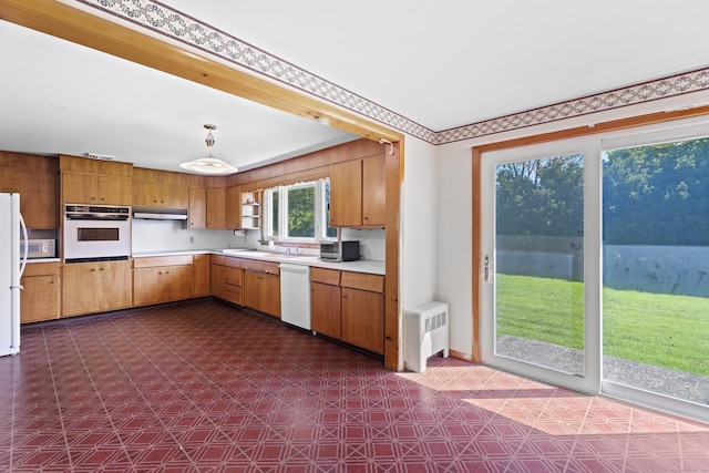 241 Clarks Falls Rd, North Stonington, CT 06359 - kitchen with white appliances, dark flooring, light countertops, brown cabinetry, and radiator
