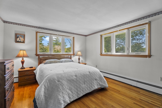 241 Clarks Falls Rd, North Stonington, CT 06359 - bedroom with a baseboard heating unit, multiple windows, wood finished floors, and a baseboard radiator