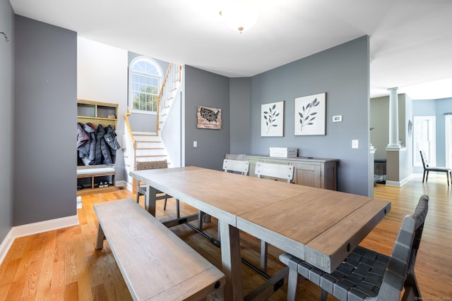 123 Cobblestone Dr, Southington, CT 06479 - dining area with decorative columns, stairs, light wood-style flooring, and baseboards