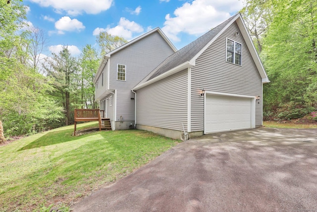 view of home's exterior featuring asphalt driveway, a wooden deck, a lawn, and roof with shingles