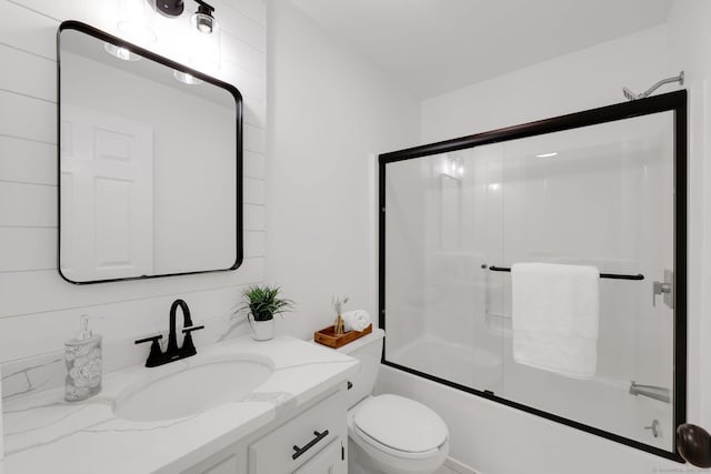 full bathroom with vanity, shower / bath combination with glass door, and toilet