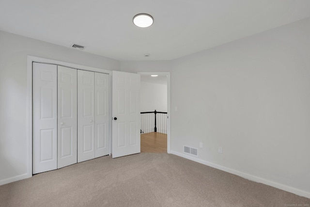 unfurnished bedroom with carpet floors, baseboards, and a closet