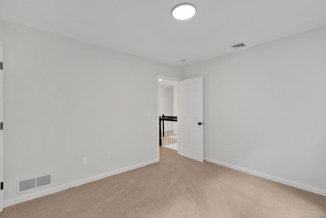 carpeted empty room featuring baseboards