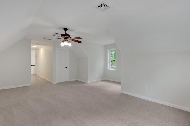 bonus room featuring vaulted ceiling, light colored carpet, baseboards, and ceiling fan