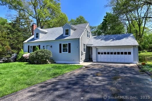32 Lenox Ave, Norwalk, CT 06854 - cape cod house with a chimney, an attached garage, a front lawn, and asphalt driveway