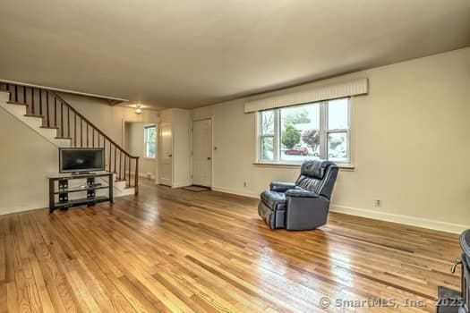 32 Lenox Ave, Norwalk, CT 06854 - unfurnished room featuring stairs, wood finished floors, and baseboards
