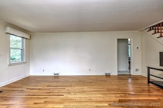 32 Lenox Ave, Norwalk, CT 06854 - unfurnished living room with stairway, wood finished floors, and baseboards