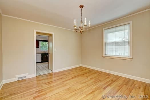 32 Lenox Ave, Norwalk, CT 06854 - unfurnished room featuring ornamental molding, a chandelier, wood finished floors, and baseboards