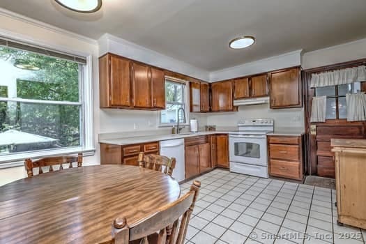 32 Lenox Ave, Norwalk, CT 06854 - kitchen with white appliances, a sink, under cabinet range hood, light countertops, and light tile patterned floors
