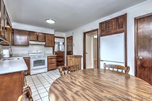 32 Lenox Ave, Norwalk, CT 06854 - kitchen with electric range, refrigerator, light tile patterned floors, under cabinet range hood, and light countertops