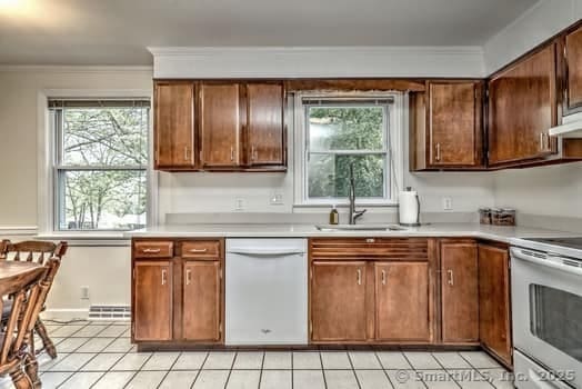 32 Lenox Ave, Norwalk, CT 06854 - kitchen featuring white appliances, light countertops, a sink, crown molding, and light tile patterned floors