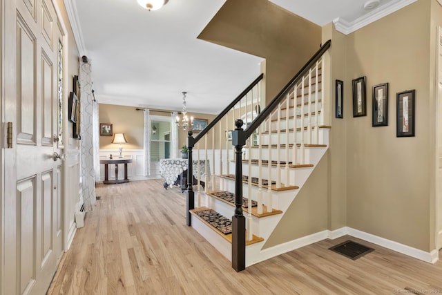 15 Westwood Rd, Essex, CT 06442 - foyer entrance with light wood-style floors, ornamental molding, stairs, a chandelier, and baseboards