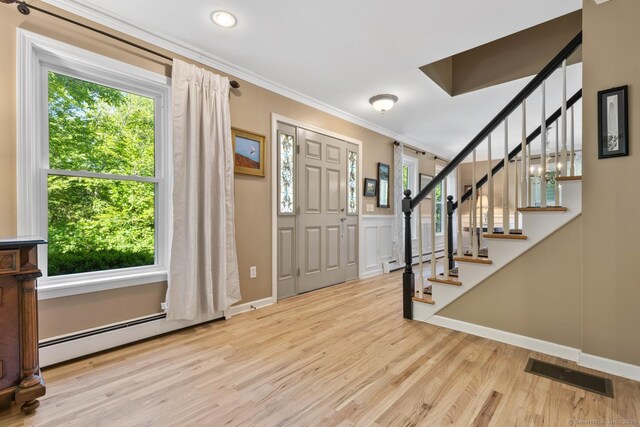 15 Westwood Rd, Essex, CT 06442 - foyer with crown molding, a baseboard heating unit, wood finished floors, stairway, and recessed lighting