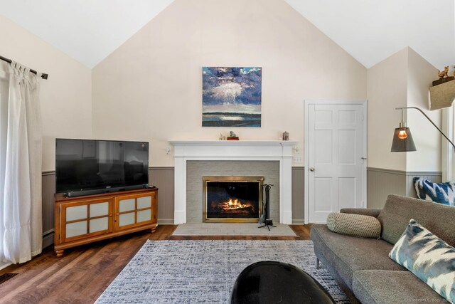 15 Westwood Rd, Essex, CT 06442 - living area with high vaulted ceiling, wainscoting, wood finished floors, and a fireplace with flush hearth