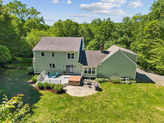 15 Westwood Rd, Essex, CT 06442 - rear view of property featuring a patio area, a chimney, a yard, a view of trees, and a shingled roof