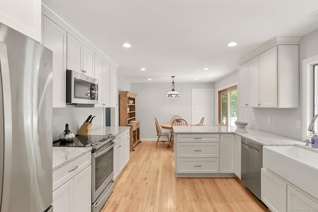 95 Vista Rd, Wilton, CT 06897 - kitchen with appliances with stainless steel finishes, a sink, white cabinets, a peninsula, and recessed lighting