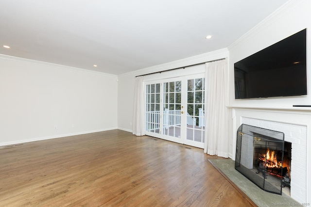 11 Norman Ln, Darien, CT 06820 - unfurnished living room featuring a warm lit fireplace, wood finished floors, ornamental molding, and recessed lighting