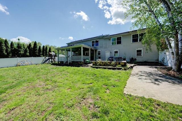 back of property featuring a playground and a sunroom