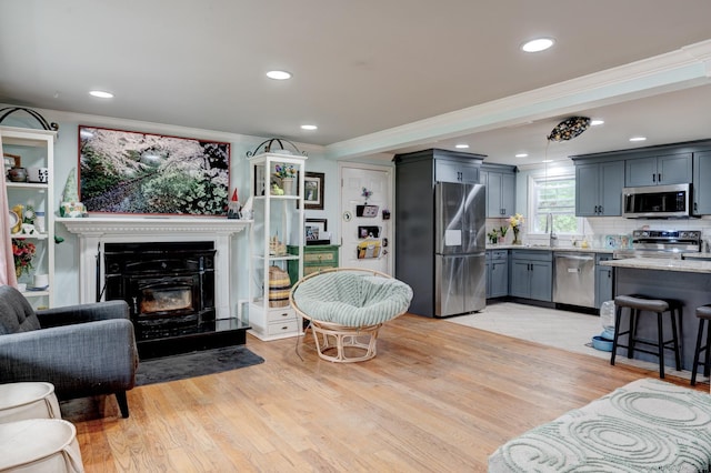 living area with recessed lighting, ornamental molding, and light wood-style floors