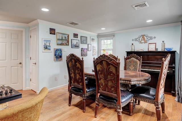 dining room with light wood finished floors, ornamental molding, baseboards, and recessed lighting