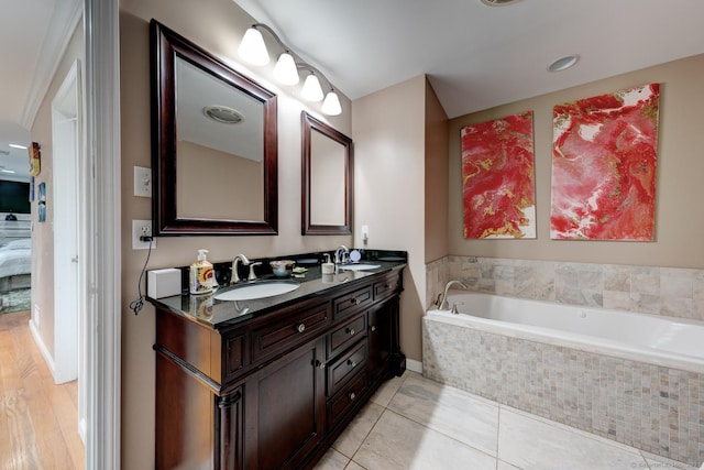 ensuite bathroom featuring a garden tub, double vanity, and tile patterned flooring