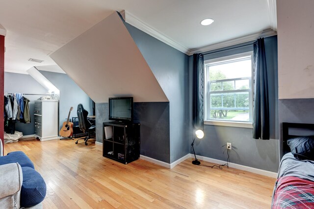 bedroom featuring wood finished floors, baseboards, and ornamental molding