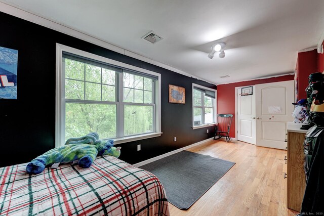 bedroom with light wood finished floors and baseboards