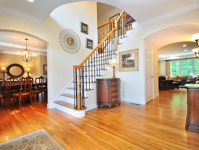 21 Pheasant Hill Rd, Canton, CT 06019 - staircase featuring wood finished floors, a chandelier, ornamental molding, arched walkways, and baseboards