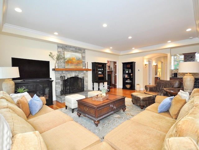 21 Pheasant Hill Rd, Canton, CT 06019 - living area with arched walkways, wood finished floors, crown molding, a stone fireplace, and recessed lighting