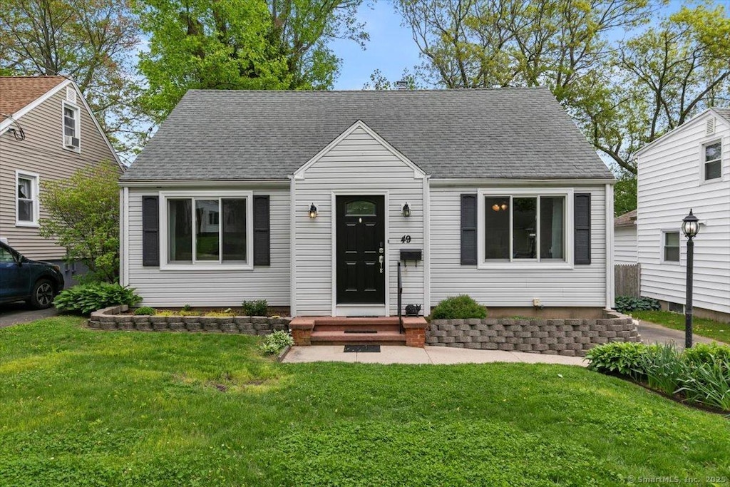 49 Hillside Ave, West Haven, CT 06516 - view of front facade featuring a front lawn and a shingled roof