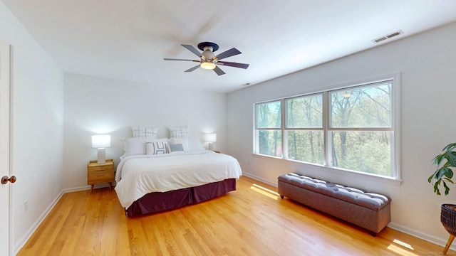 bedroom with light wood-type flooring, baseboards, and a ceiling fan