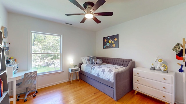 bedroom featuring multiple windows, light wood finished floors, baseboards, and ceiling fan
