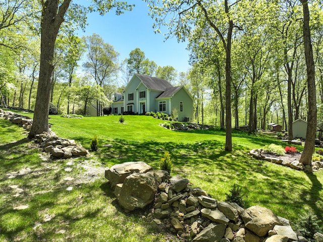view of green lawn featuring a shed and an outdoor structure