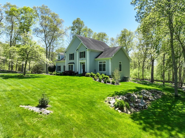 rear view of house featuring central AC and a yard
