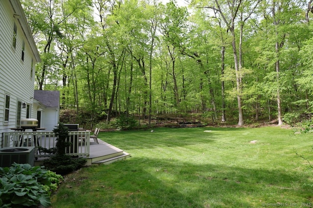 7 Indian Trl, Woodbridge, CT 06525 - view of green lawn with central AC, a wooden deck, and a view of trees