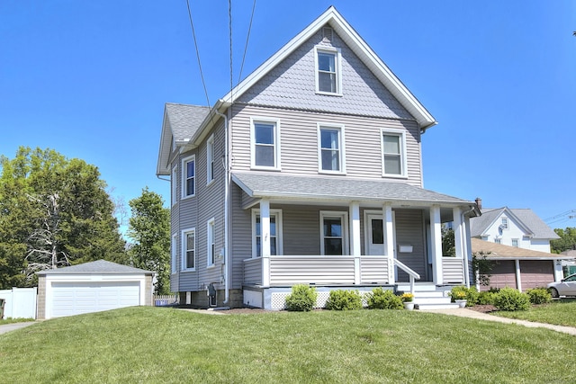 victorian home with covered porch, an outbuilding, a garage, and a front yard