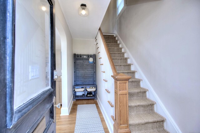 stairs featuring wood finished floors and baseboards