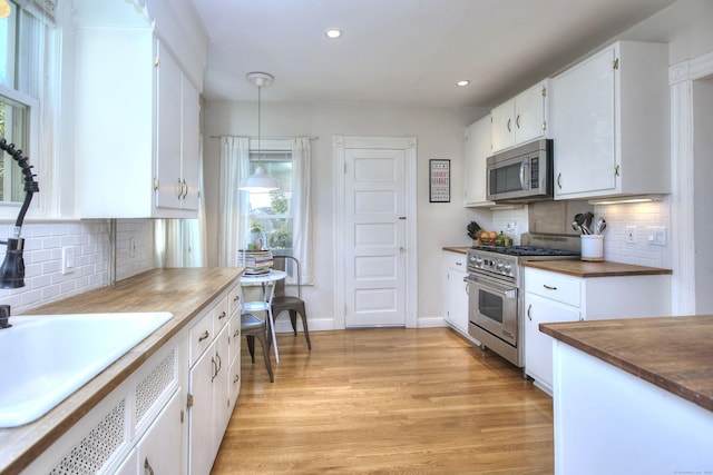 kitchen with appliances with stainless steel finishes, tasteful backsplash, white cabinetry, and recessed lighting